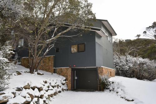 a house with a garage in the snow at Albina in Thredbo