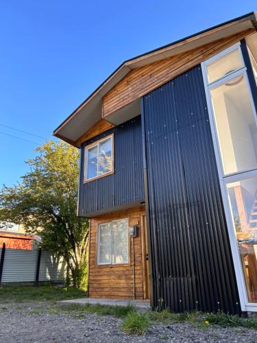 uma casa com metal ondulado preto em Casas Altos del Simpson em Coihaique
