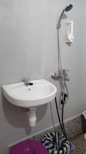 a bathroom with a white sink and a shower at Tange Guest House in Ruteng