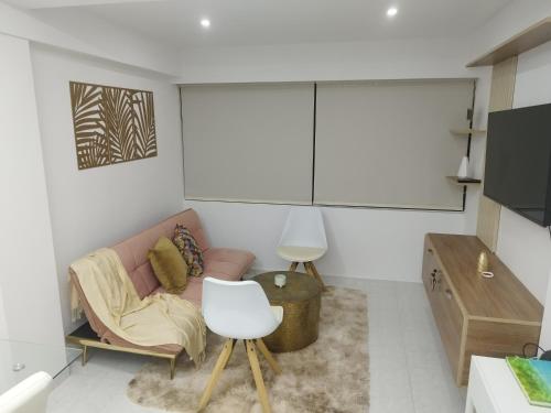 ein Wohnzimmer mit einem Sofa und einem Stuhl in der Unterkunft Apartamento moderno frente al mar in Cartagena de Indias