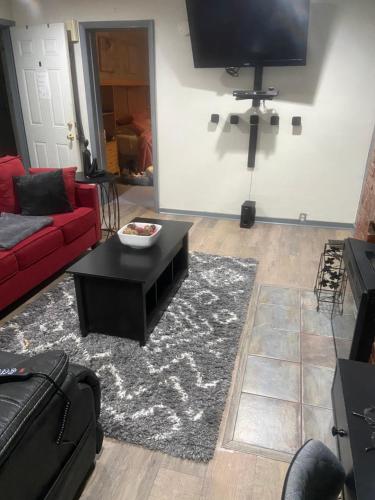 a living room with a red couch and a black coffee table at Cuddys Place in Pittsburgh