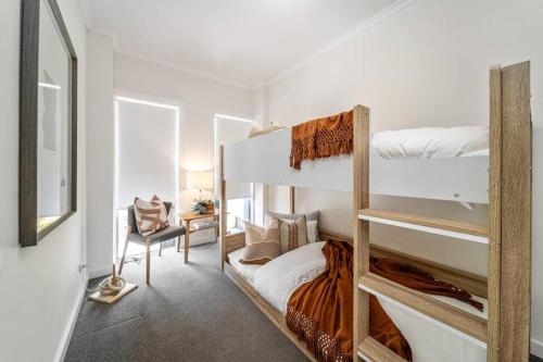 - une chambre avec 2 lits superposés et une chaise dans l'établissement Urban Luxe - Designer, BBQ, WiFi, à Keswick