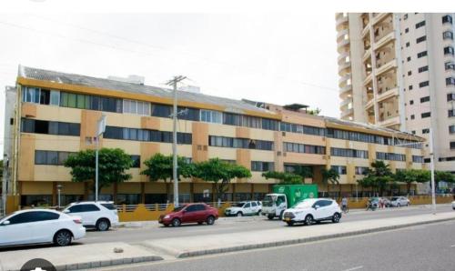 a large building with cars parked in a parking lot at Apartamento moderno frente al mar in Cartagena de Indias