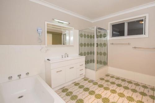 a white bathroom with a sink and a shower at Erulisse in Jindabyne