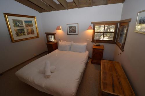 ein Schlafzimmer mit einem großen Bett mit einem Teddybär darauf in der Unterkunft Hi Plains Garadyigan Chalet in Thredbo