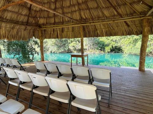 a group of chairs sitting on a wooden deck at Crystal Creek Lodge in Orange Walk