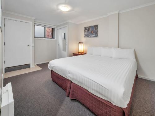 a bedroom with a large bed and a window at Jasper 1 in Jindabyne