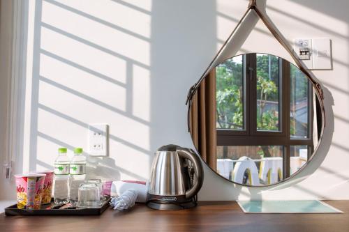 a mirror sitting on top of a wooden table at BIG Hotel Huế in Hue