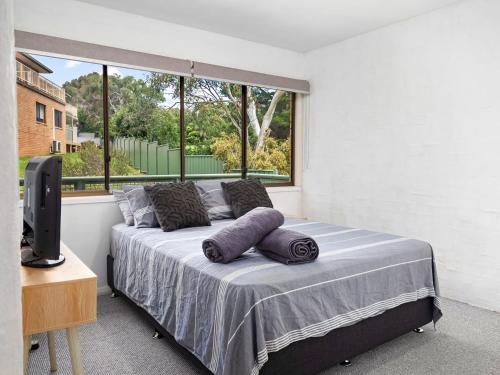 a bedroom with a bed with two pillows on it at Kirwan 19 in Jindabyne