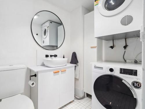 a bathroom with a washing machine and a sink at Kirwan 19 in Jindabyne