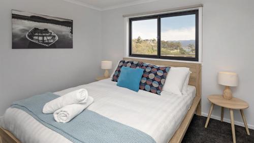 a bedroom with a large bed and a window at Kunama Haven in Jindabyne