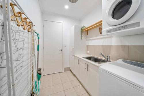 a white kitchen with a sink and a microwave at Chalfont Way @ Glengowrie - WiFi BBQ Family in Somerton Park