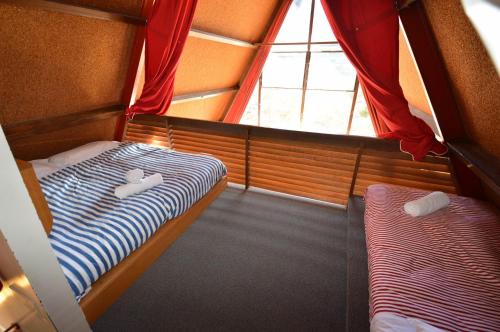 une petite chambre avec deux lits et une fenêtre dans l'établissement Moonbah Ski Lodge, à Thredbo