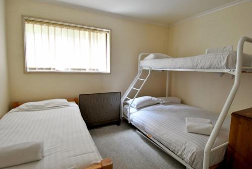 two bunk beds in a room with a window at Mowamba E1 in Thredbo
