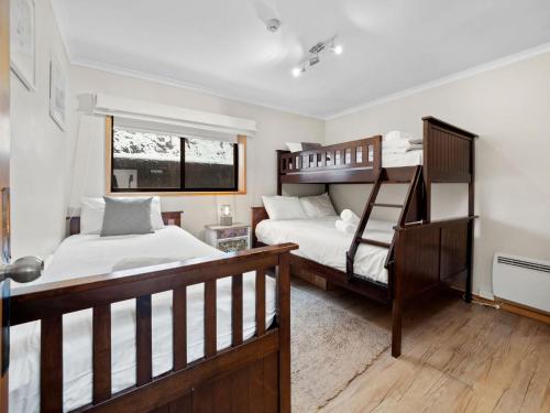 a bedroom with two bunk beds and a window at Mowamba D1 in Thredbo