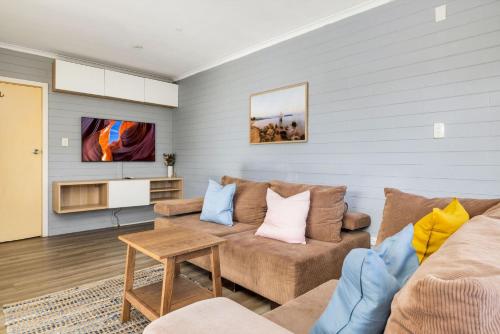 a living room with a couch and a tv at Mountain View 1 in Jindabyne