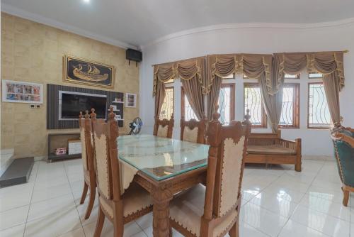 a dining room with a glass table and chairs at RedDoorz at Jalan Siliwangi Tasikmalaya in Tasikmalaya