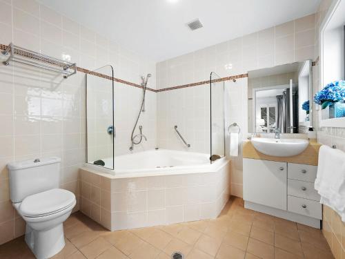 a bathroom with a tub and a toilet and a sink at Snowbound 1 in Thredbo