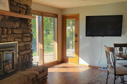 a living room with a fireplace and a flat screen tv at LI Airbnb - NWA mt bike, hike, and golf retreat in Bella Vista
