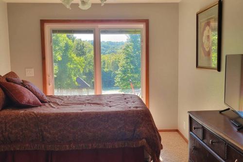a bedroom with a bed and a large window at LI Airbnb - NWA mt bike, hike, and golf retreat in Bella Vista