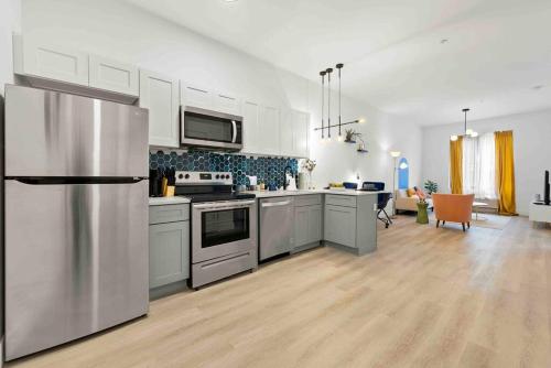 a kitchen with white cabinets and a stainless steel refrigerator at Contemporary Luxury BR, EWR AIRPT, Nyc, Free Pkng, Prudential CNTR, American Dream Mall in Elizabeth