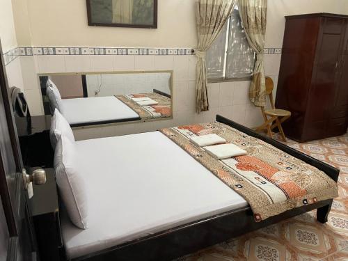 two beds in a room with a mirror at QUỲNH HOA HOTEL in Ho Chi Minh City
