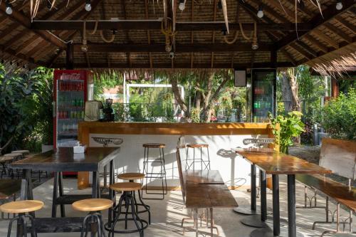 un bar avec des tables et des tabourets dans un restaurant dans l'établissement Phrip Phri Luxury Pool Villas, à Phetchaburi