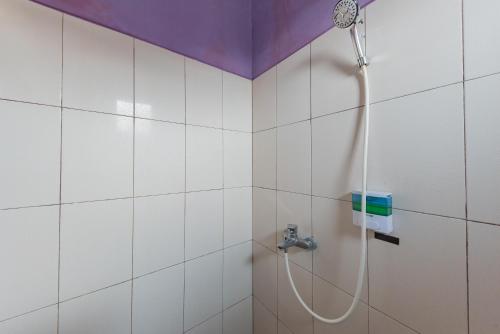 a bathroom with a shower with a hose at RedDoorz Syariah @ Jalan Siliwangi Tasikmalaya in Tasikmalaya