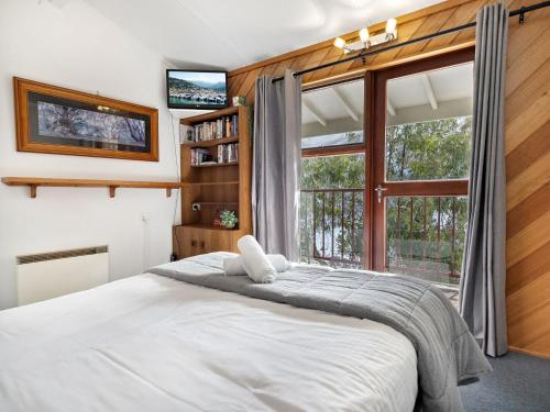 a bedroom with a large bed and a large window at Tyrola 1 in Thredbo