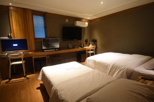 a hotel room with two beds and a desk with a computer at Lava Hotel in Seoul