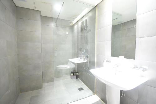 a white bathroom with a sink and a toilet at Lava Hotel in Seoul