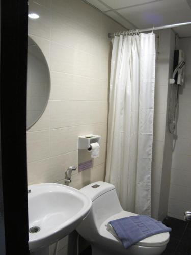 a bathroom with a white toilet and a sink at The Airy Residence in Lat Krabang