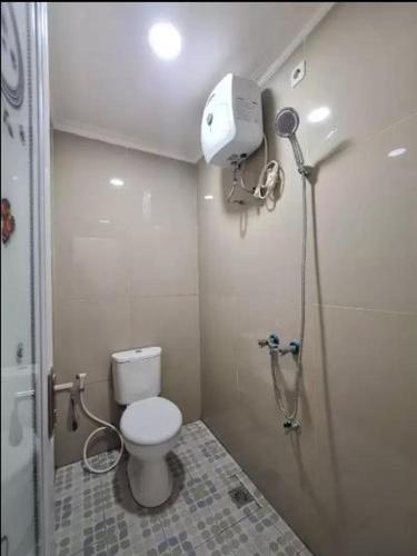 a small bathroom with a toilet and a shower at Highlander Stay Palembang in Palembang
