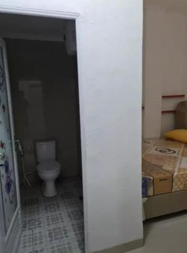 a bathroom with a toilet in a room with boxes at Highlander Stay Palembang in Palembang