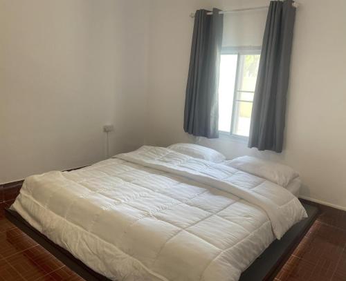a white bed in a bedroom with a window at ANOU HOSTEL in Pakse