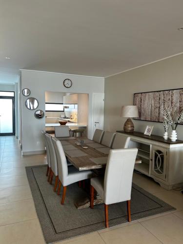 uma sala de jantar e sala de estar com mesa e cadeiras em The Pier 27 em Swakopmund