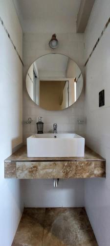 La salle de bains est pourvue d'un lavabo blanc et d'un miroir. dans l'établissement Ribera de Cacheuta Lodge, à Las Compuertas