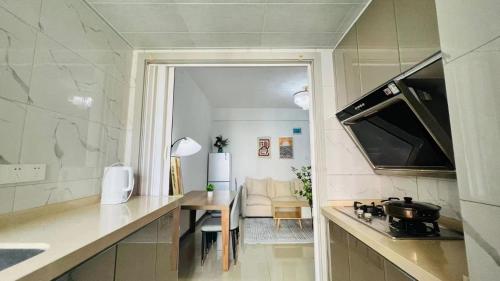a kitchen with a counter and a table and a couch at House of Great White Apartment in Shenzhen