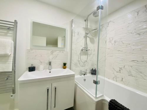 a white bathroom with a sink and a shower at Penthouse - Contractors Professionals in Gloucester