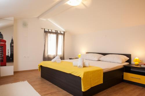 - une chambre avec un grand lit et une couverture jaune dans l'établissement Apartments Fiona - away from city crowds, à Makarska