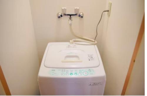 a washing machine in a corner of a bathroom at 【Shinjuku33】光回線完備パーティースペースにも使える新宿のお部屋 in Tokyo