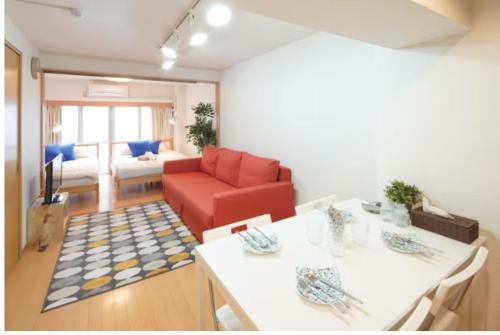 - un salon avec une table et un canapé rouge dans l'établissement 【Shinjuku33】光回線完備パーティースペースにも使える新宿のお部屋, à Tokyo