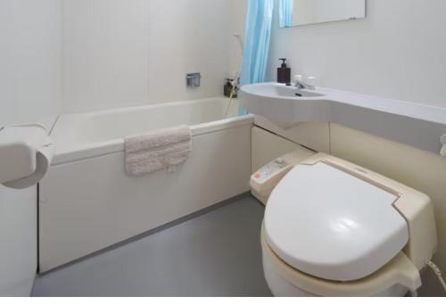 La salle de bains blanche est pourvue de toilettes et d'un lavabo. dans l'établissement 【Shinjuku33】光回線完備パーティースペースにも使える新宿のお部屋, à Tokyo