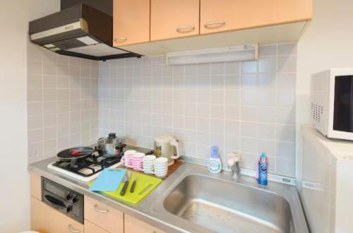 a kitchen with a sink and a stove at 【Shinjuku33】光回線完備パーティースペースにも使える新宿のお部屋 in Tokyo