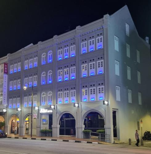 a building with blue lights on the side of it at Bliss Hotel Singapore in Singapore