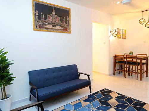 a living room with a blue couch and a table at D'Luna Homestay Terengganu - LADANG GEMILANG 2 in Kuala Terengganu
