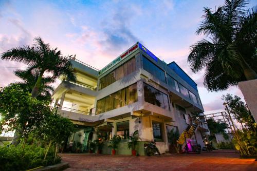 a building with a palm tree in front of it at FabHotel Sharma & Vishnu Garden in Bhopal