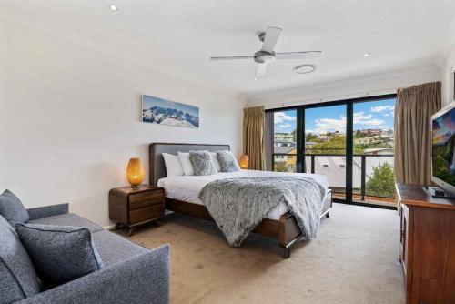 Un dormitorio con una cama, un sofá y un televisor. en Stockyards 1, en Jindabyne