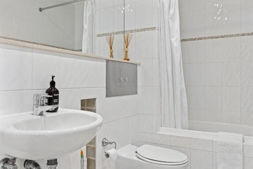 Un baño blanco con lavabo e inodoro. en Stockyards 1, en Jindabyne