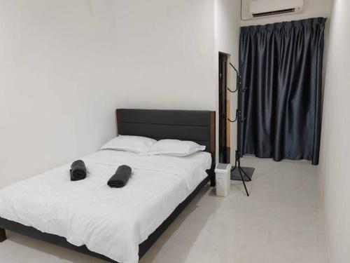 Un dormitorio con una cama con zapatos. en D'Sroja Home in Jerantut, en Jerantut